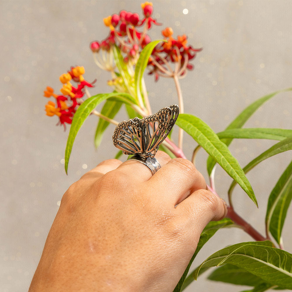 Anillo mariposa monarca posada sobre hoja.